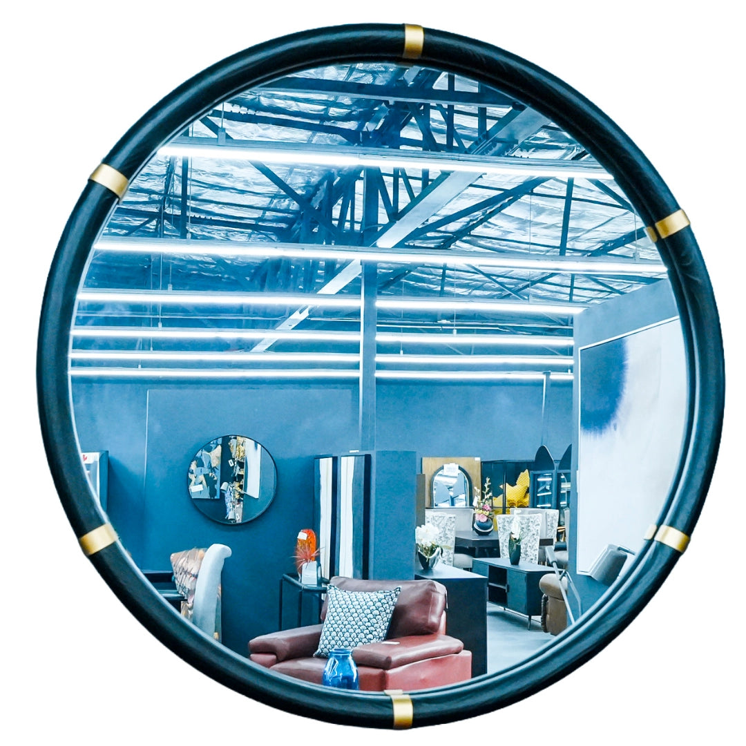 Circular mirror reflecting a modern space with blue walls and furniture.