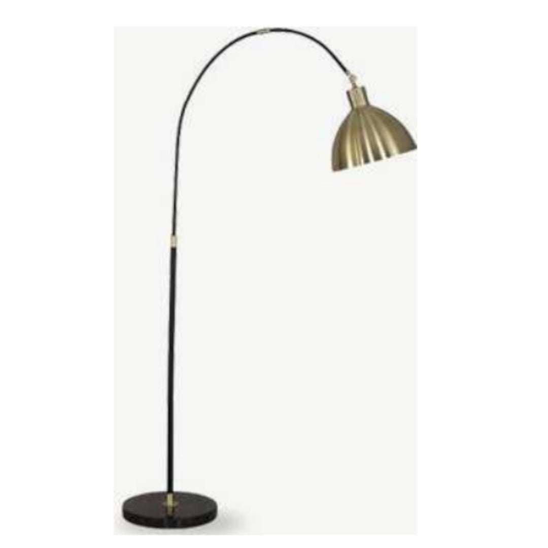 Floor lamp with a black base and brass arching shade on a white background
