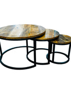 Set of three round wooden tables with metal bases on a white background