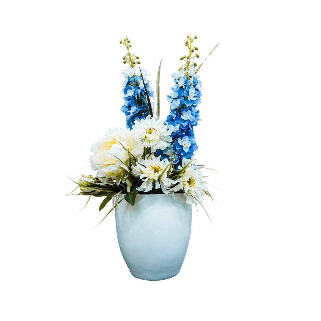 Floral arrangement with blue and white flowers in a light blue vase on a white background