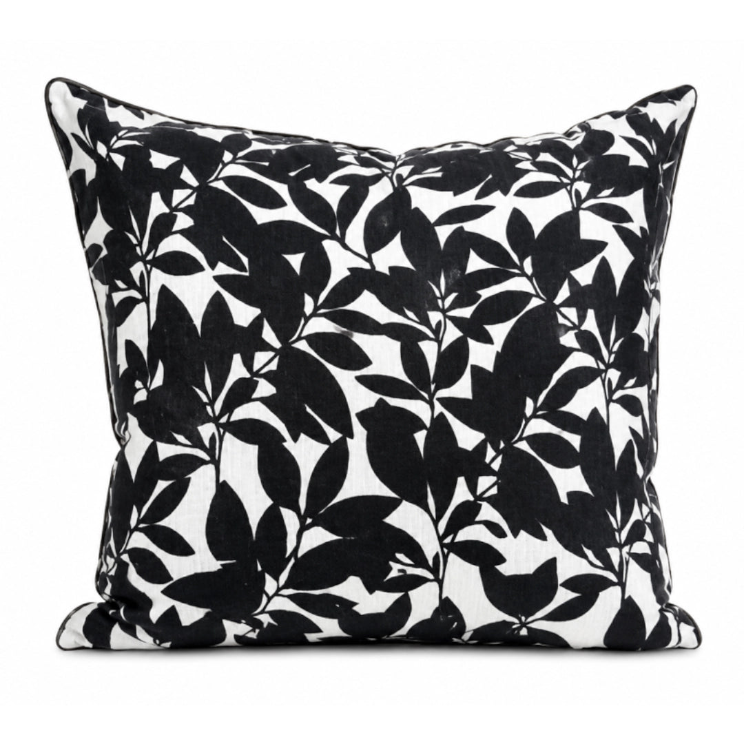 Black leaf patterned pillow on a white background