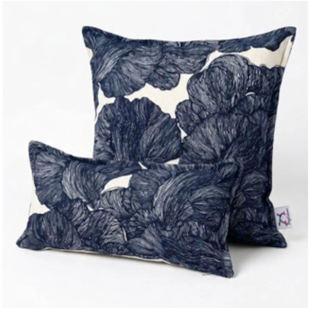 Two navy blue leaf-patterned pillows on a white background