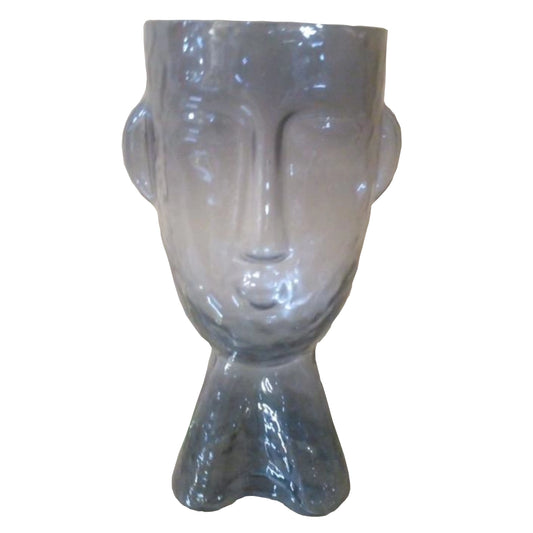 A Grey glass ornament shaped like a face on a white background