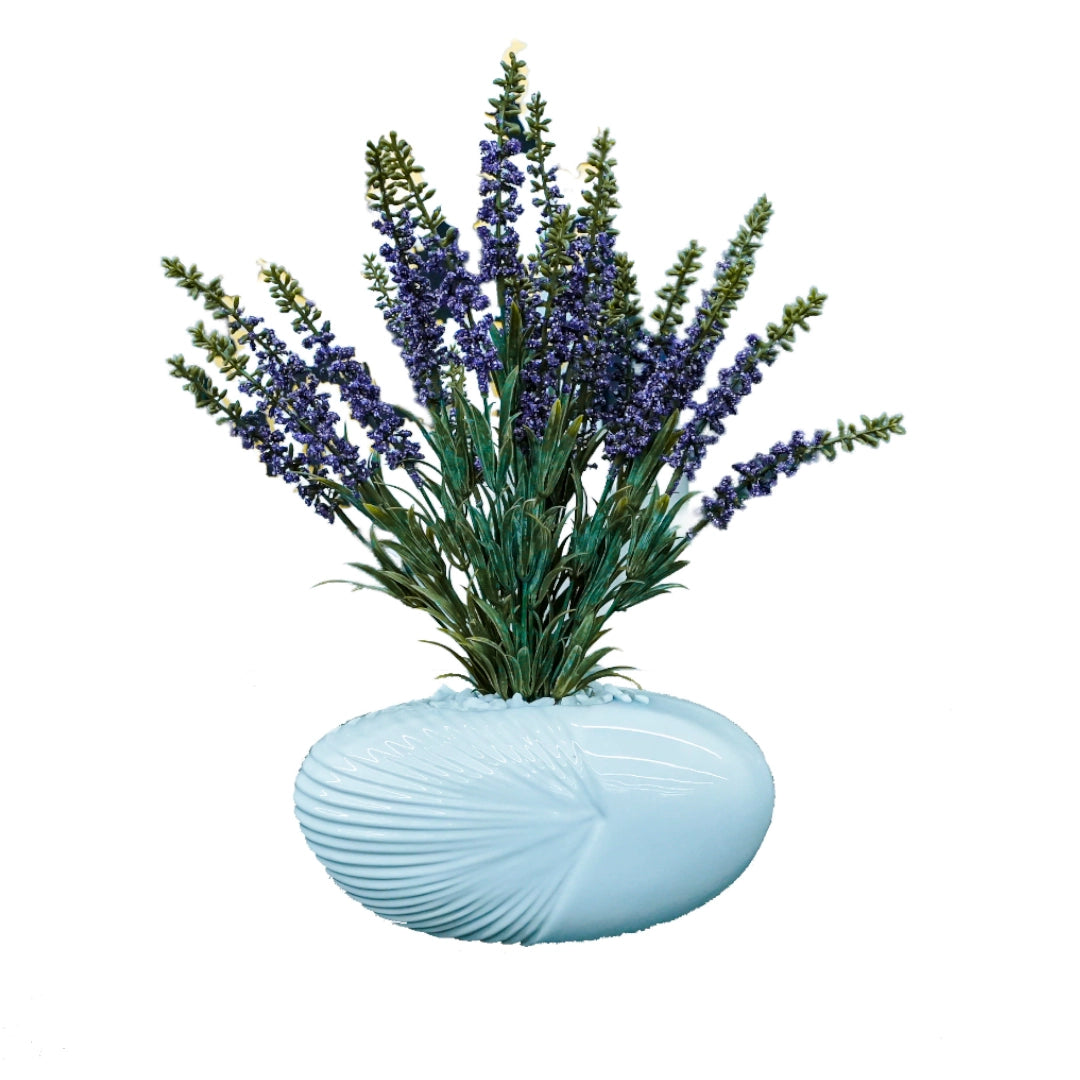 Artificial lavender plant in a light blue vase on a white background