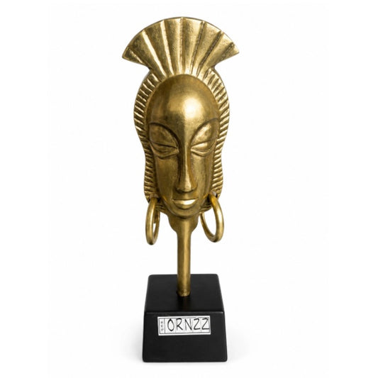 A metallic face sculpture with a black stand on a white background
