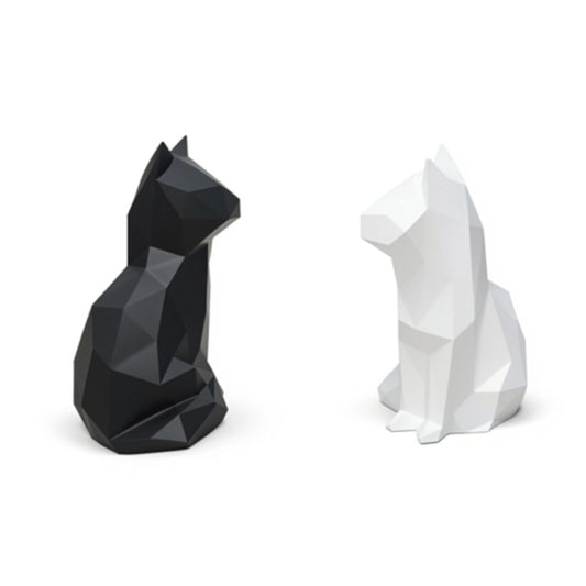Two cat statues, one black and one white, on a white background