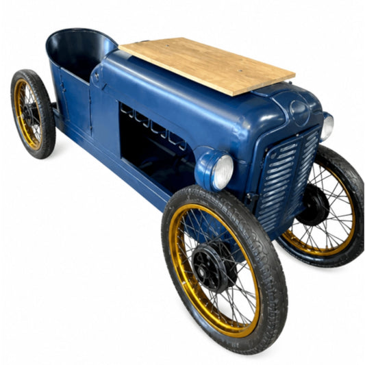 A vintage-style blue toy car with a wooden panel on top, black tires, and gold-rimmed wheels, shown on a plain white background.